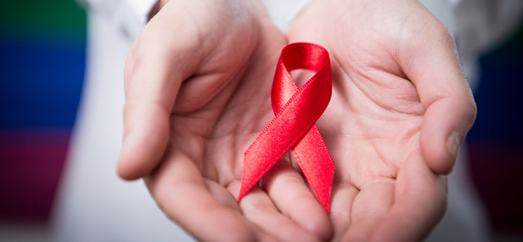 two hands holding red AIDS awareness ribbon