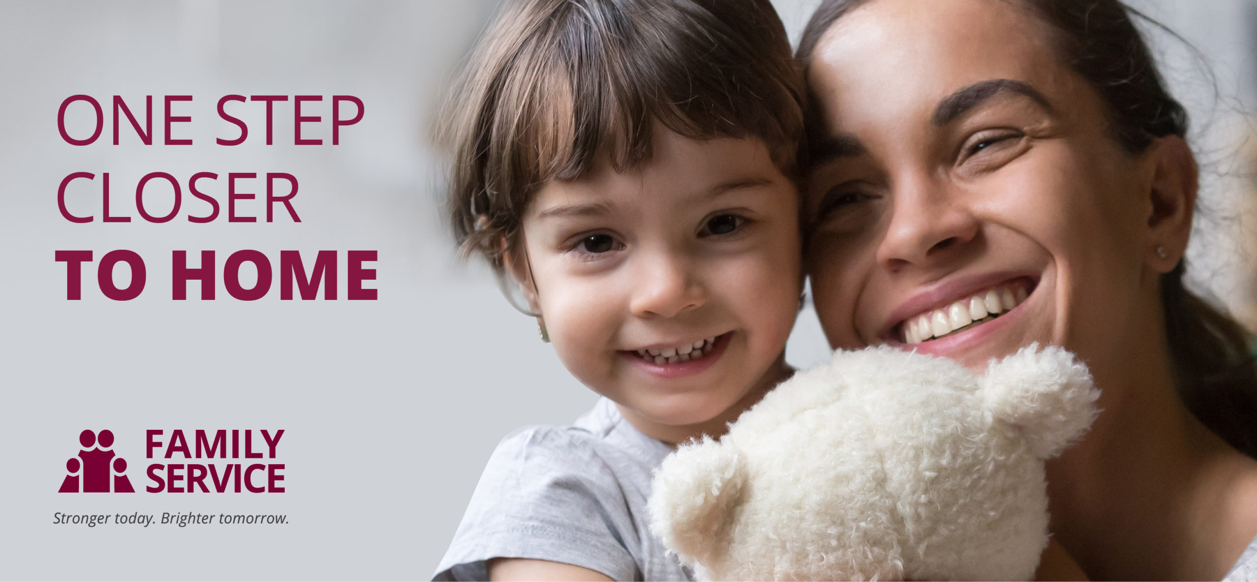 happy mom holding toddler with teddy bear