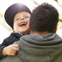 dad holding young happy boy