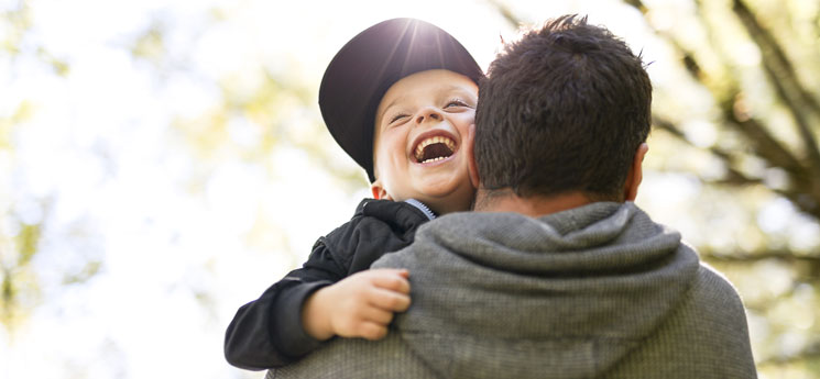 dad holding young happy boy